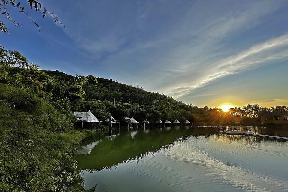 Indiana-style tents are seen during sunset at We Camp, a glamping site located in Yuen Long, Hong Kong on Aug. 22, 2021. From the Great Wall to the picturesque Kashmir valley, Asia's tourist destinations are looking to domestic visitors to get them through the COVID-19 pandemic's second year. With international travel heavily restricted, foreign tourists can't enter many countries and locals can't get out. The difficulty of traveling abroad has made glamping, or glamourous camping, popular in Hong Kong. (AP Photo/Katie Tam)