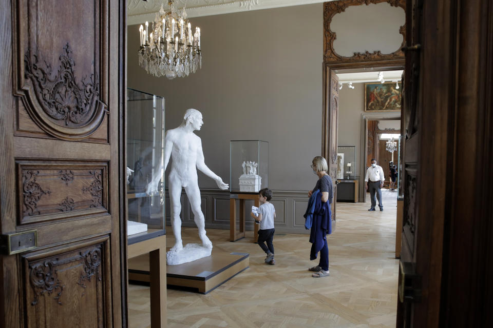 Travelers visit the Rodin museum in Paris Tuesday, July 7, 2020. The Musee Rodin is reopening this morning albeit with a worrying loss of visitors and income caused by the four-months closure. Museum director, Catherine Chevillot, estimates the loss incurred by the crisis to be around 4.4 million euros (4.9 US dollars) and alleviated by the 1.4 million euro sales of bronze editions of Rodin statues. The museum doesn't sell Rodin statue originals but can sell 12 bronze replica editions of each of them, as it has been for 100 years. (AP Photo/Christophe Ena)