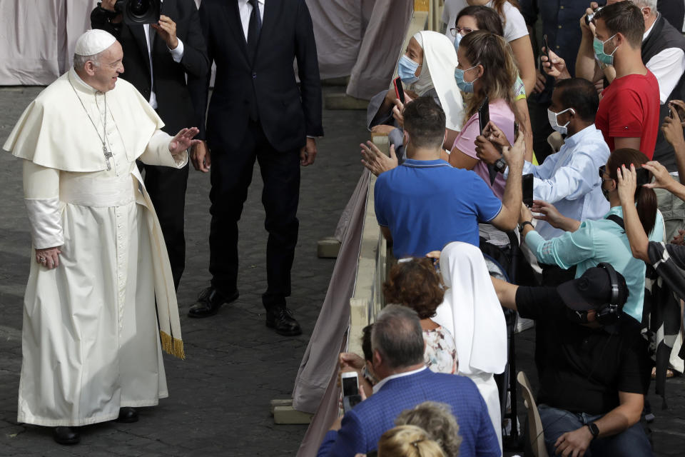 Pope Francis speaks to faithful wearing face masks to prevent the spread of COVID-19 as he arrives for his general audience, the first with faithful since February when the coronavirus outbreak broke out, in the San Damaso courtyard, at the Vatican, Wednesday, Sept. 2, 2020. (AP Photo/Andrew Medichini)