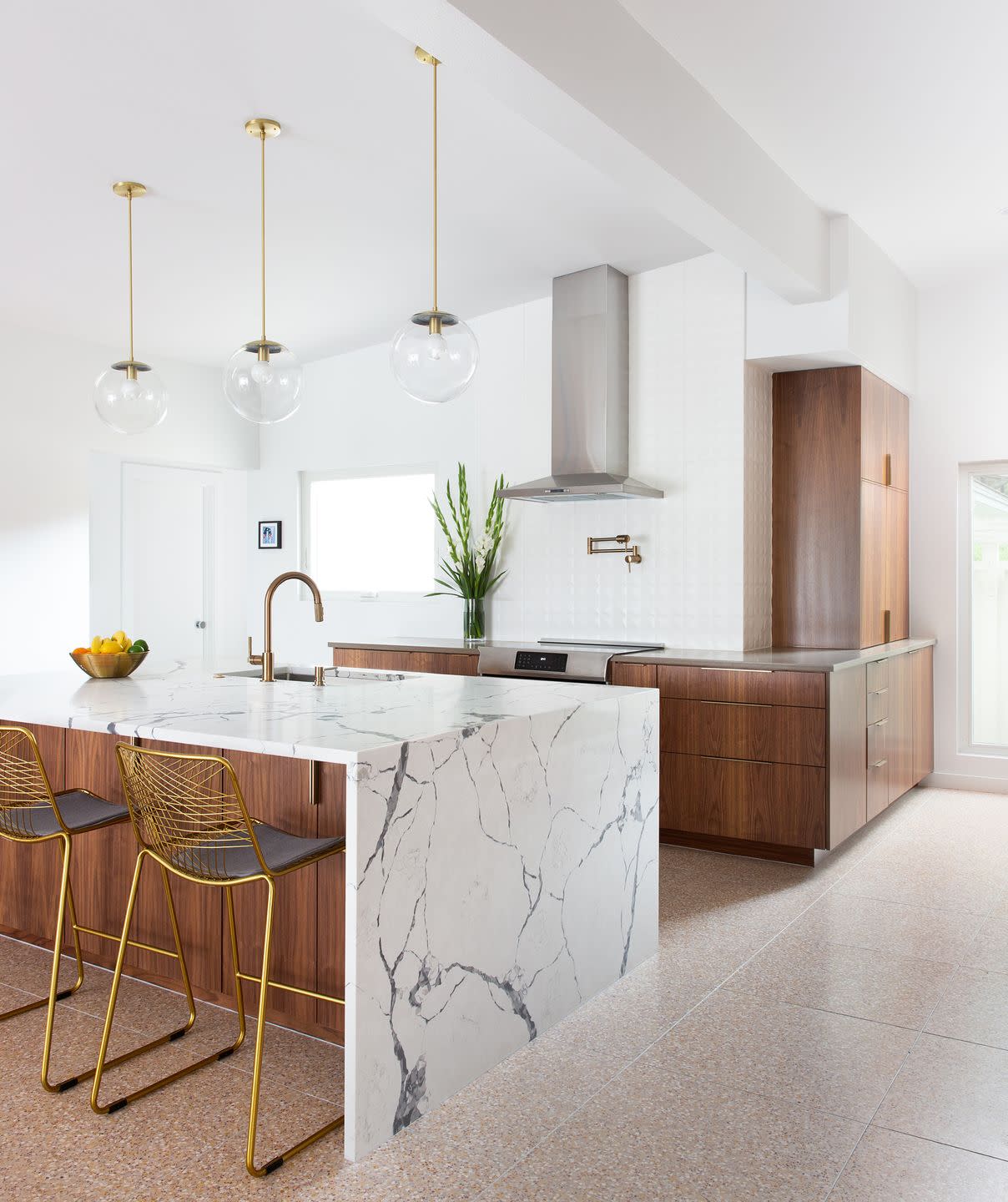 white kitchen with marble island and wood cabinets