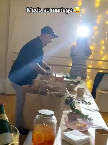 <p>Zoe Satche @satchephotography</p> A guest brings in McDonald's food to couple's wedding reception.