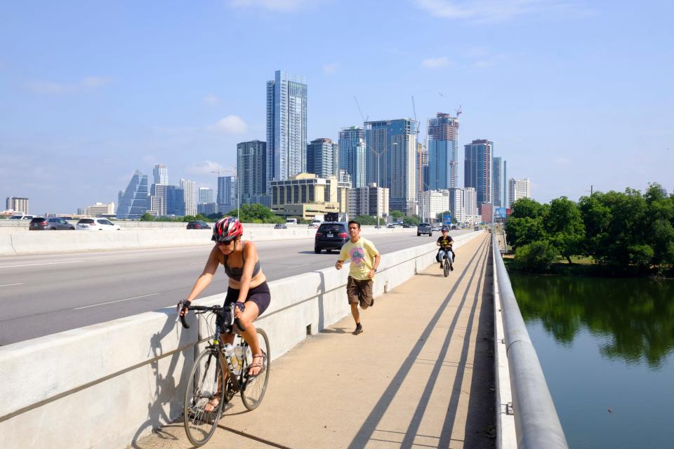 Cyclists and runners traverse the Interstate 35 bridge over Lady Bird Lake earlier this month. More plans for safety from traffic near the Butler trail are in the works.