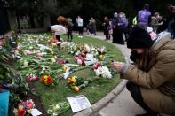 Varias personas depositan flores al exterior del Castillo de Windsor tras la muerte del príncipe Felipe, en Windsor, cerca de Londres, Reino Unido.