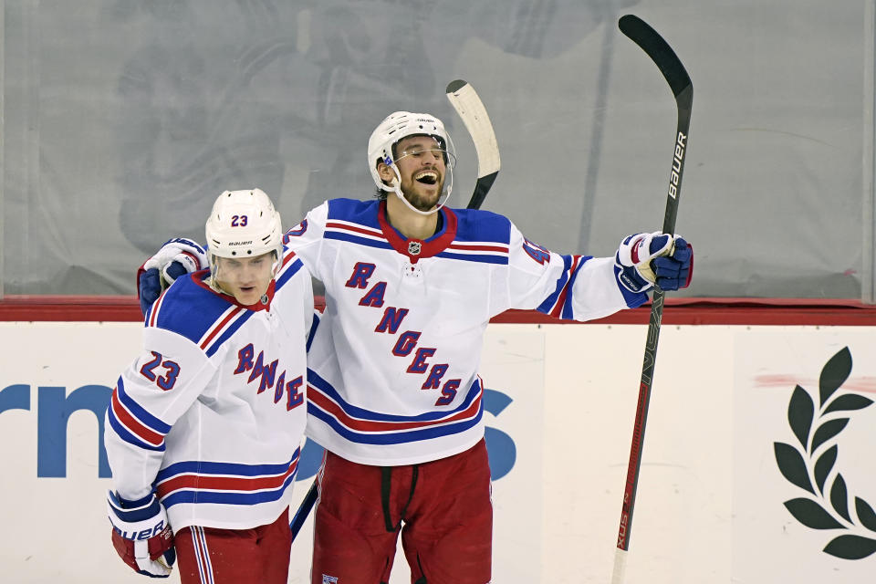 New York Rangers defenseman Brendan Smith (42) celebrates with Rangers defenseman Adam Fox (23) after scoring the Rangers' fifth goal during the third period of an NHL hockey game against the New Jersey Devils, Thursday, March 4, 2021, in Newark, N.J. The Rangers defeated the Devils 6-1. (AP Photo/Kathy Willens)