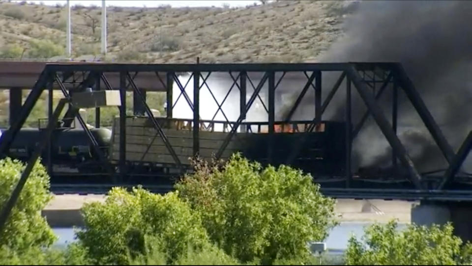 Smoke fills the sky at the scene of a train derailment in Tempe, Ariz., on Wednesday, July 29, 2020. Officials say a freight train traveling on a bridge that spans a lake in the Phoenix suburb derailed and set the bridge ablaze and partially collapsing the structure. There were no immediate reports of any leaks. (AP Photo/Pool)