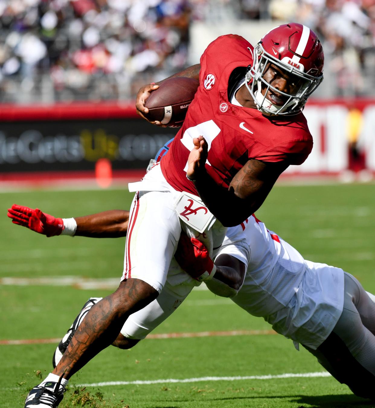 Sep 23, 2023; Tuscaloosa, Alabama, USA; Alabama Crimson Tide quarterback Jalen Milroe (4) runs the ball and evades a tackle by Mississippi Rebels safety John Saunders Jr. (5) at Bryant-Denny Stadium. Mandatory Credit: Gary Cosby Jr.-USA TODAY Sports