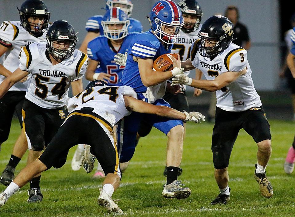 Mapleton High School's Kollin Cline (5) is tackled by South Central High School's Parker Gray (24) and Hagen Adams (3) during high school football action Friday, Oct. 8, 2021 at Mapleton High School.