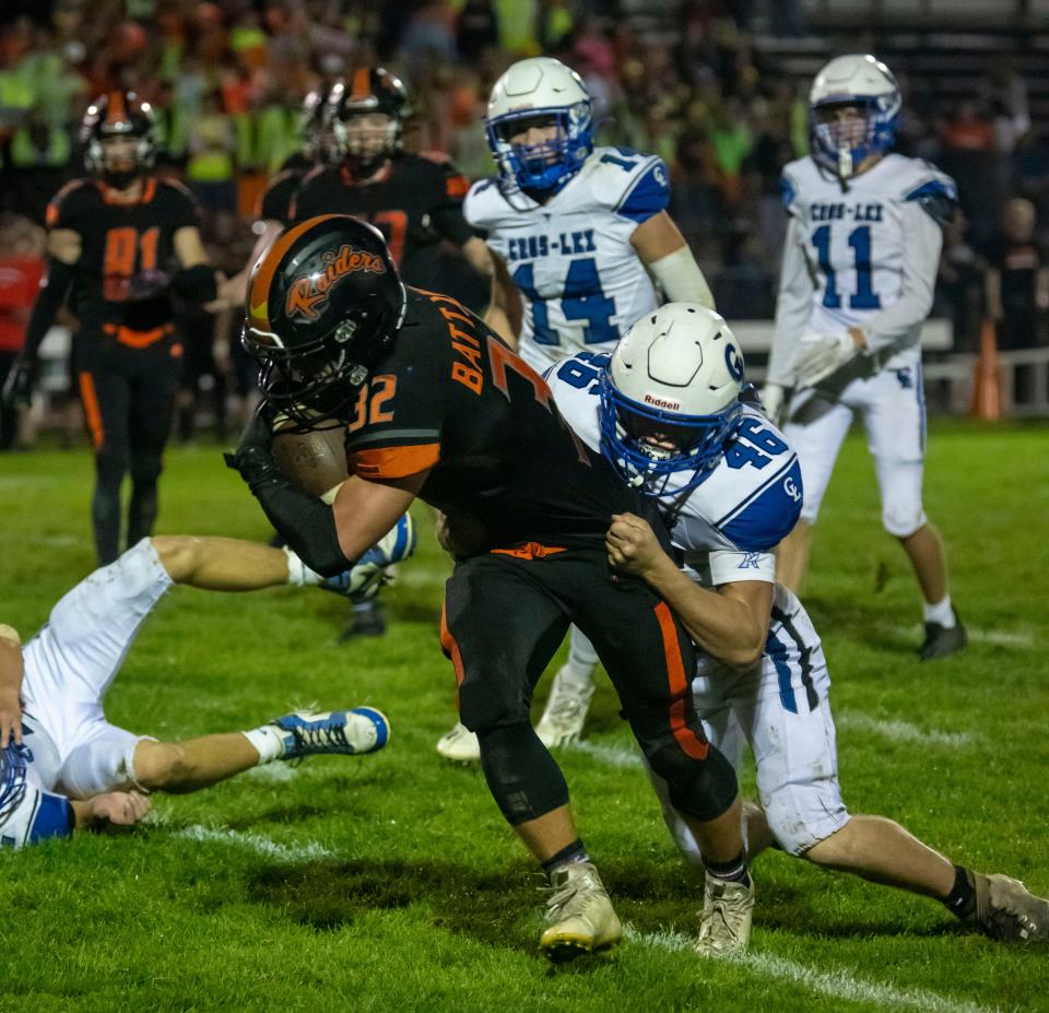 Almont’s Chase Battani runs as Cros-Lex’s Noah Jackson tackles him Friday, Sept. 29, 2023, during their football game at Almont High School.