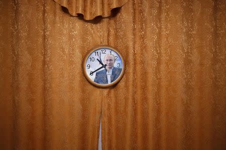 A wall clock with a picture of Russian President Vladimir Putin is seen in this photo illustration taken in a hotel room in Kazan, Russia, July 31, 2015. REUTERS/Stefan Wermuth
