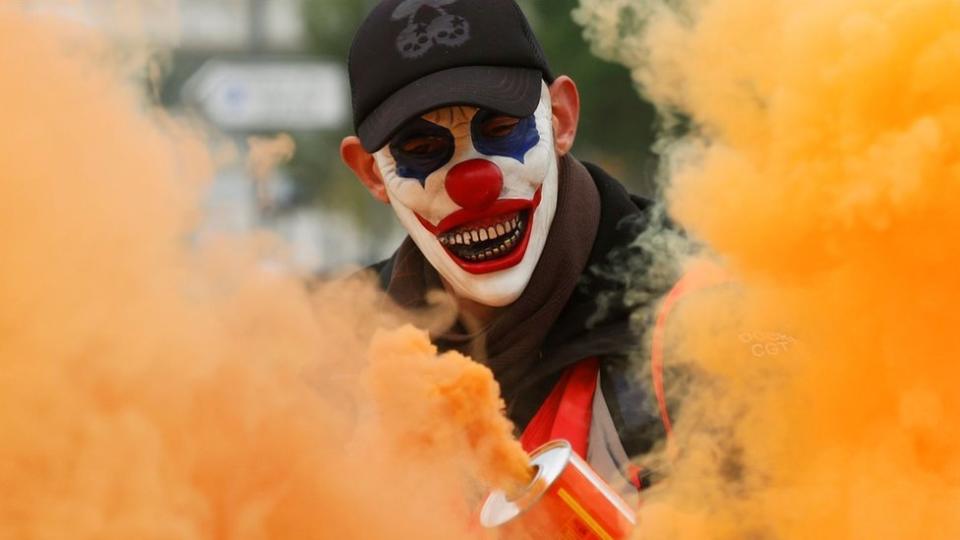 Manifestante con la cara pintada de payaso.