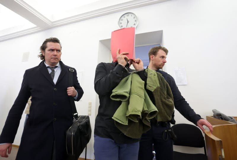 US defendant is led into a courtroom with his lawyer Philip Mueller (L) at the regional court in Kempten. A 31-year-old US citizen has received a lifelong prison sentence for murder, attempted murder and rape after attacking two women near southern Germany's famed Neuschwanstein Castle last year, the court announced on Monday. Karl-Josef Hildenbrand/dpa