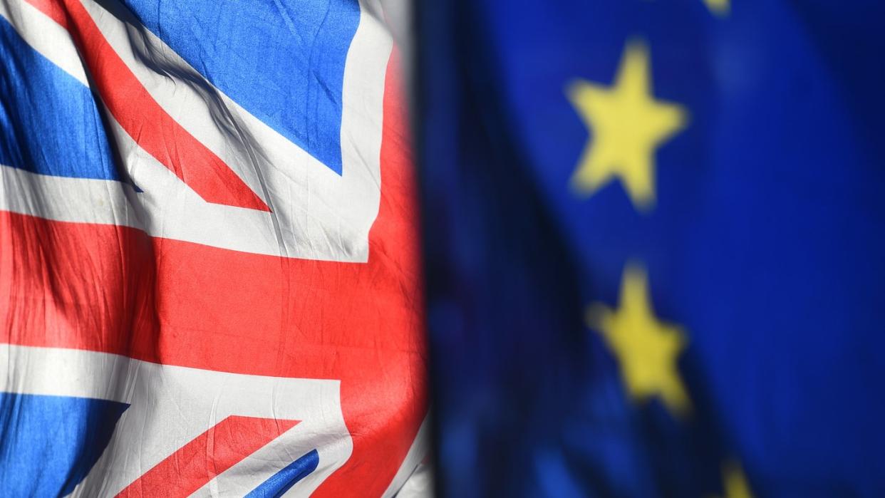 Eine Flagge der Europäischen Union und eine Flagge von Großbritannien wehen vor dem Parlament in Westminster.