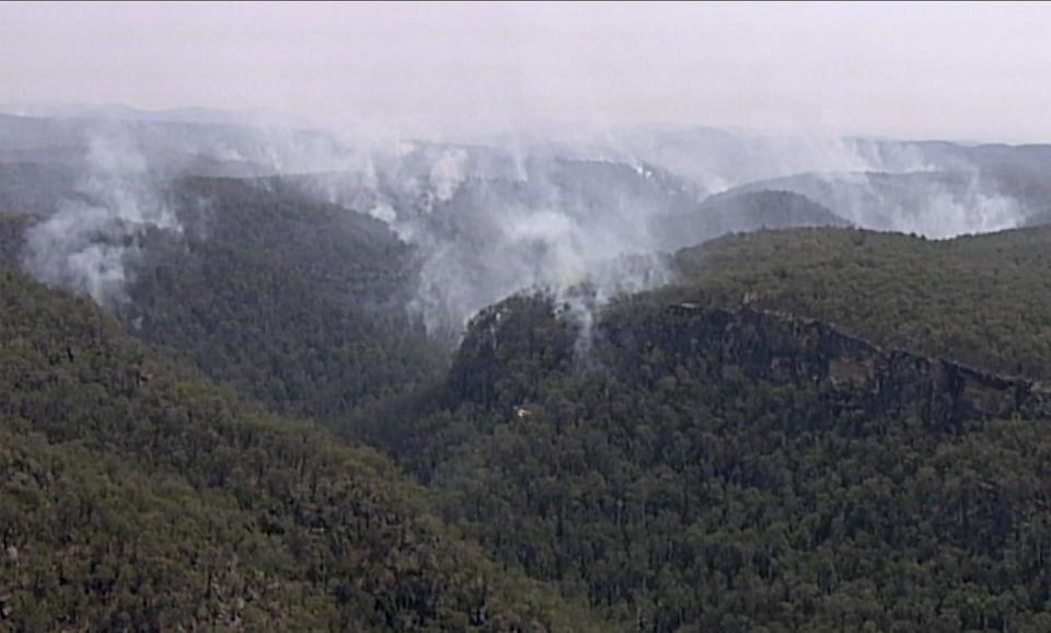 In this image made from video, smoke rises from wildfires Friday, Dec. 27, 2019, in the Blue Mountains, New South Whales, Australia. Firefighters battling wildfires in Australia’s most populous state are attempting to make headway amid favorable conditions, before an "extreme heatwave" hits embattled areas on the weekend. (Australian Broadcasting Corporation via AP)