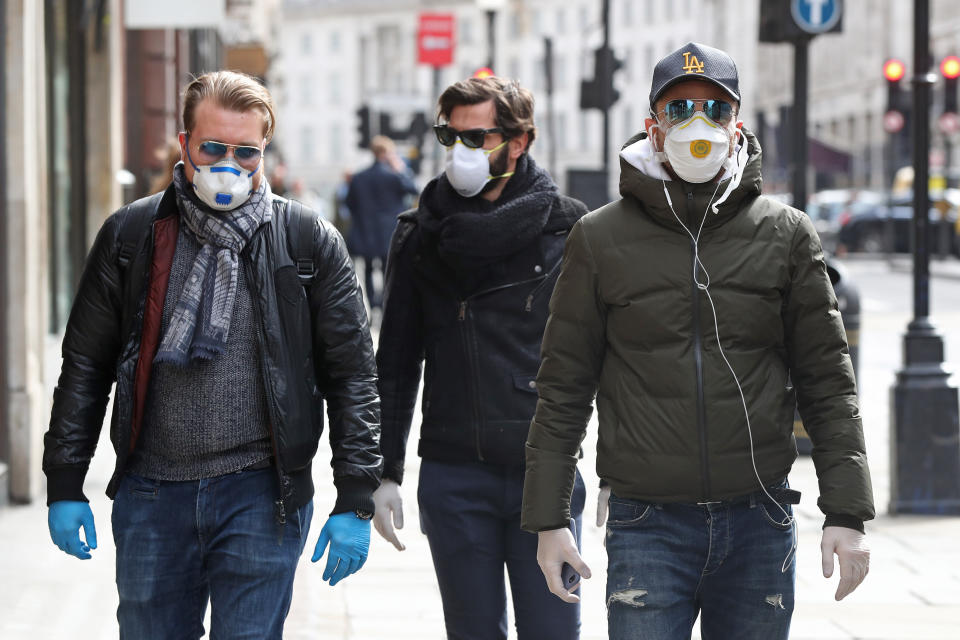 People wearing face masks and gloves in Regents Street in London the day after Prime Minister Boris Johnson called on people to stay away from pubs, clubs and theatres, work from home if possible and avoid all non-essential contacts and travel in order to reduce the impact of the coronavirus pandemic.