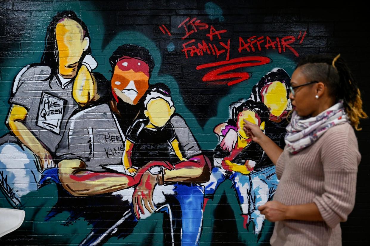 Tiffany Nordé talks about a mural depicting her family at the new Rock the Block Studio on Thursday, Dec. 2, 2021, in Lansing's REO Town. Artist Keyon Lovett painted the mural.