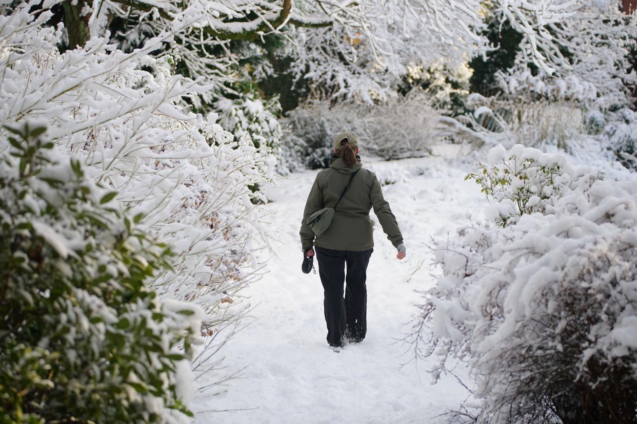 A woman walks through the snow in the Walled garden at Camp Hill in Woolton, Liverpool. Much of Britain is facing another day of cold temperatures and travel disruption after overnight lows dropped below freezing for the bulk of the country. A 