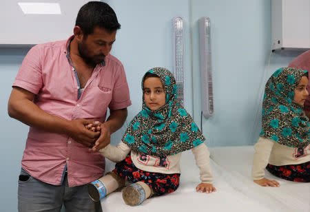 Maya Meri, 8, waits with her uncle Hussein at a prosthetic center in Istanbul, Turkey, July 5, 2018. Picture taken July 5, 2018. REUTERS/Osman Orsal