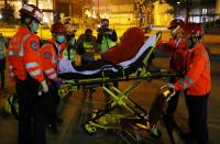 Paramedics escort a protester to an ambulance at the campus of the Polytechnic University (PolyU) in Hong Kong