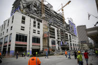 Construction workers look on after a large portion of a hotel under construction suddenly collapsed in New Orleans on Saturday, Oct. 12, 2019. Several construction workers had to run to safety as the Hard Rock Hotel, which has been under construction for the last several months, came crashing down. It was not immediately clear what caused the collapse or if anyone was injured. (Scott Threlkeld/The Advocate via AP)