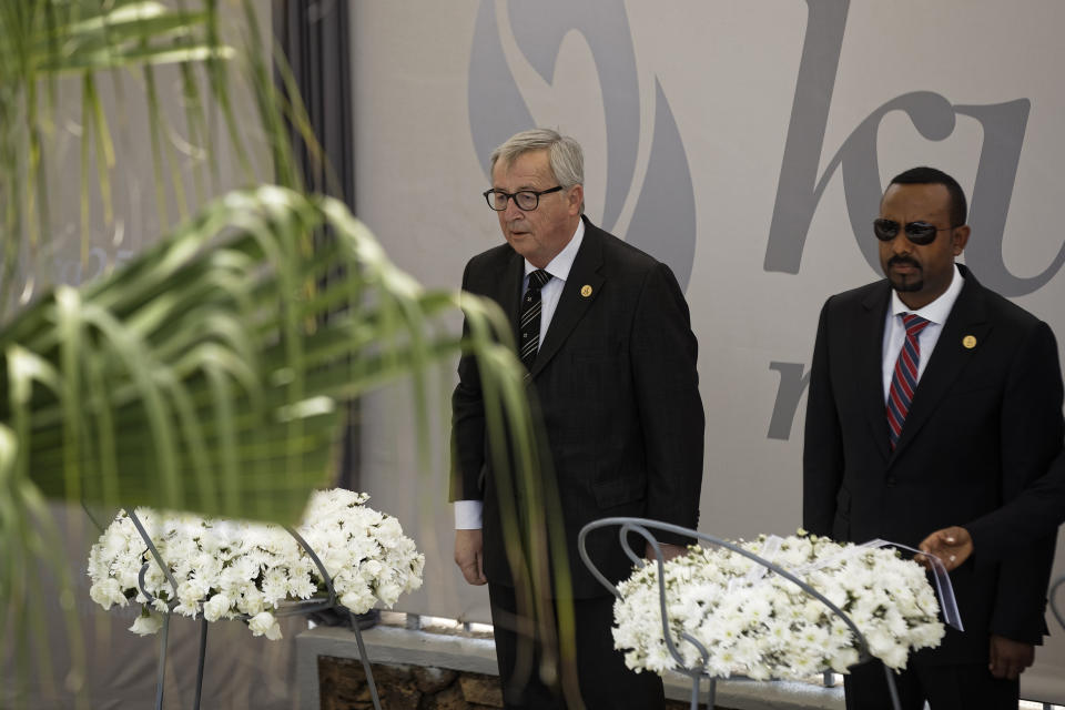 President of the European Commission Jean-Claude Juncker, left, and Ethiopia's Prime Minister Abiy Ahmed, right, prepare to lay wreaths at the Kigali Genocide Memorial in Kigali, Rwanda Sunday, April 7, 2019. Rwanda is commemorating the 25th anniversary of when the country descended into an orgy of violence in which some 800,000 Tutsis and moderate Hutus were massacred by the majority Hutu population over a 100-day period in what was the worst genocide in recent history. (AP Photo/Ben Curtis)