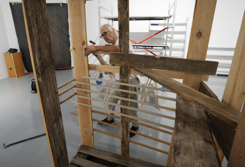 Lars Vilks, a Swedish artist, constructs an exhibit at the Ujazdowski Castle Center for Contemporary Art in Warsaw, Poland, Wednesday Aug. 25, 2021. The exhibition which opens Friday at the Polish state museum features the works of provocative artists in what organizers describe as a celebration of free speech, and a challenge to political correctness and "cancel culture" on the political left. Some critics, however, accuse the organizers of the show titled "Political Art" of giving a platform to anti-Semitic, racist and Islamophobic messages. Vilks lives under police protection for making a drawing of a dog with the head of the Prophet Muhammed. The drawing enraged many Muslims in 2007 and sparked death threats from extremists. (AP Photo/Czarek Sokolowski)