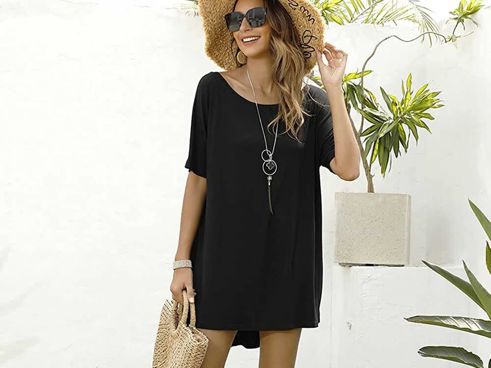 A woman wearing a large floppy hat and a black tshirt dress.