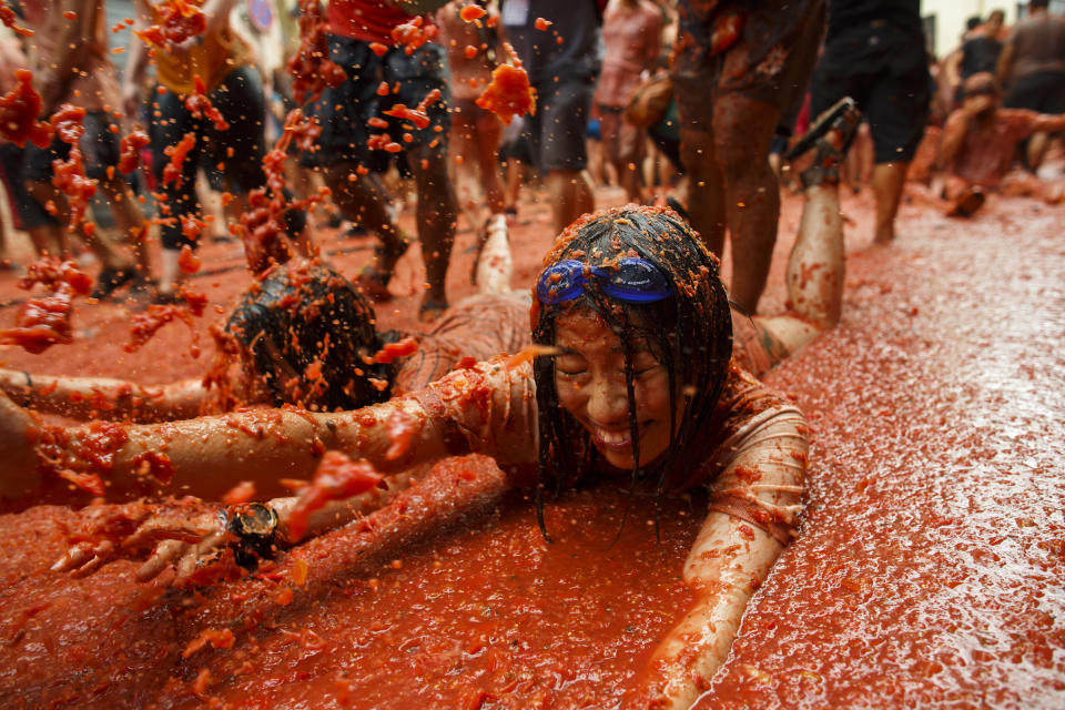 <p>Revellers enjoy the atmosphere in tomato pulp while participating the annual Tomatina festival on Aug. 30, 2017 in Bunol, Spain. (Photo: Pablo Blazquez Dominguez/Getty Images) </p>
