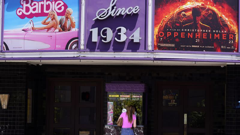A patron buys a movie ticket underneath a marquee featuring the films “Barbie” and “Oppenheimer” at the Los Feliz Theatre, Friday, July 28, 2023, in Los Angeles.