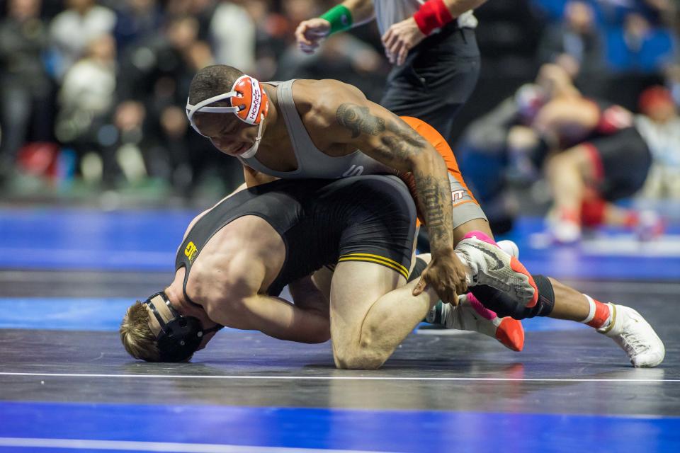 Mar 17, 2023; Tulsa, OK, USA; Virginia Tech wrestler Mekhi Lewis (red ankles) wrestles Iowa wrestler Nelson Brands in a 174 pound weight class quarterfinal during the NCAA Wrestling Championships at the BOK Center.  Mandatory Credit: Brett Rojo-USA TODAY Sports