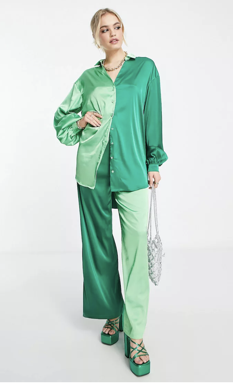Never Fully Dressed pants, $138, and shirt, $138, from ASOS shown in two-toned green satin, worn by a model with blonde hair and wearing chunky green sandals.