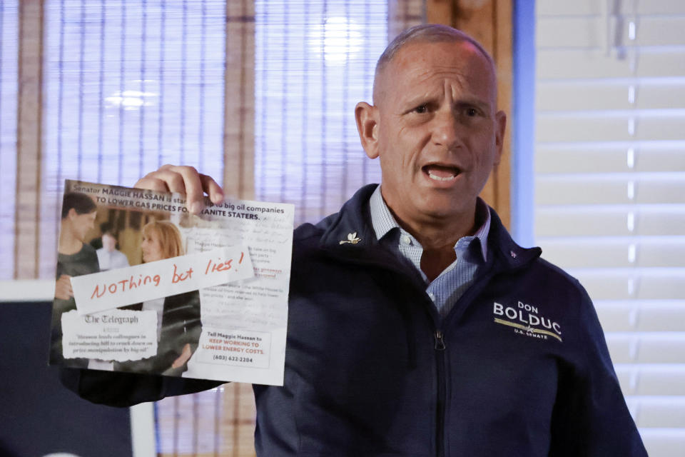 Don Bolduc, a Republican candidate for U.S. Senate in New Hampshire, holds up a mailing from the opposition as he campaigns at the Auburn Tavern, Wednesday, Oct. 5, 2022, in Auburn, N.H. (AP Photo/Mary Schwalm)