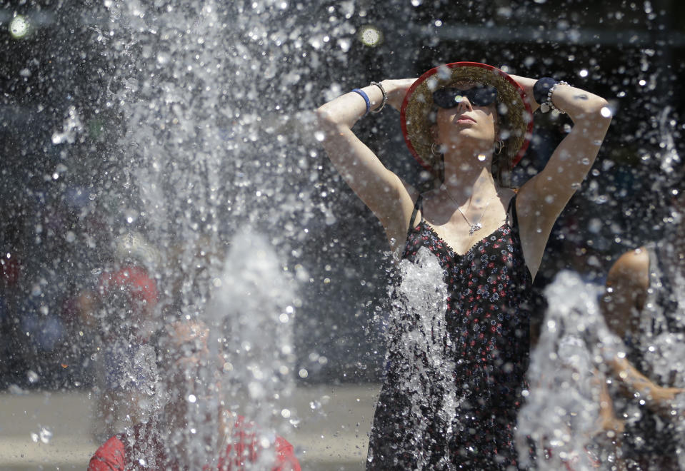 A tennis fan cools down in the fountain in the scorching heat during their second round match at the Australian Open tennis championship in Melbourne, Australia, Thursday, Jan. 16, 2014. (AP Photo/Aijaz Rahi)