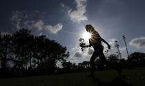 <p>Hannah Harrison carries roses during a prayer vigil following a deadly shooting at Santa Fe High School in Santa Fe, Texas, on Friday, May 18, 2018. (Photo: David J. Phillip/AP) </p>