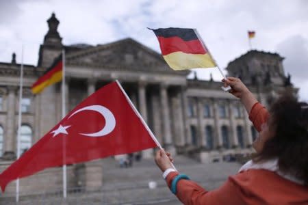 A demonstrator holds Turkish and German flags in front of the Reichstag, the seat of the lower house of parliament Bundestag in Berlin, Germany, June 1, 2016.  REUTERS/Hannibal Hanschke