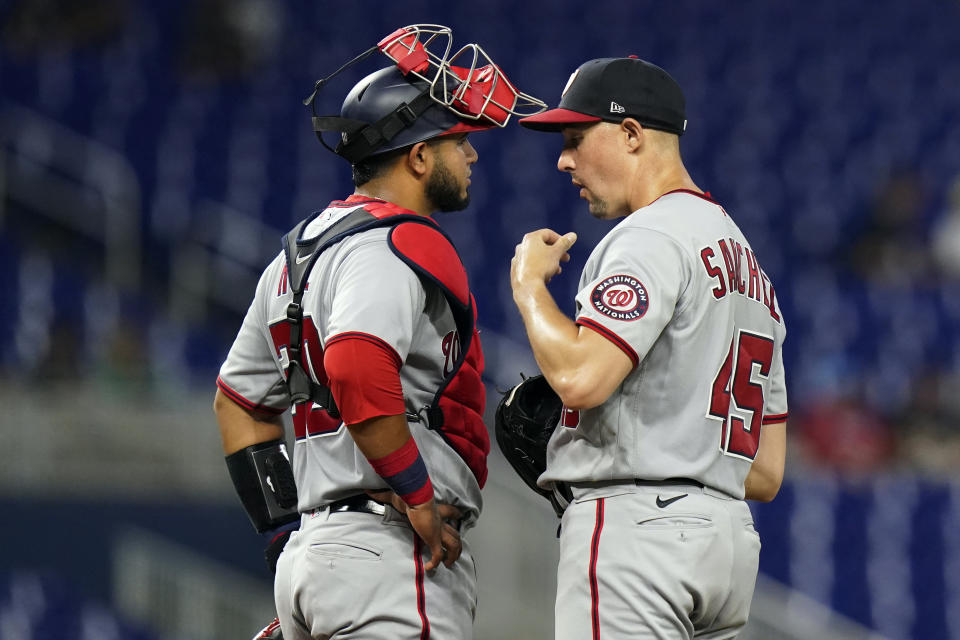 Washington Nationals catcher Keibert Ruiz, left, and starting pitcher Aaron Sanchez (45) talk during the second inning of a baseball game against the Miami Marlins, Monday, May 16, 2022, in Miami. (AP Photo/Lynne Sladky)