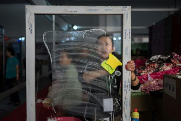 A vendor displays a window cleaning product at the Pyongyang trade fair