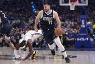 Dallas Mavericks guard Luka Doncic handles the ball as Oklahoma City Thunder guard Luguentz Dort (5) is knocked down on a pick by Dereck Lively II (2) in the first half of Game 3 of an NBA basketball second-round playoff series, in Dallas, Saturday, May 11, 2024. (AP Photo/Tony Gutierrez)