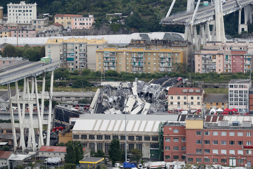 FILE - Cars are blocked on the Morandi highway bridge after a section of it collapsed, in Genoa, northern Italy, on Aug. 14, 2018. Fifty-nine people went on trial Thursday, July 7, 2022, for the 2018 collapse of Genoa’s Morandi bridge, accused of manslaughter and other charges in the deaths of 43 people.The defendants include former executives and experts of the company that manages many of Italy’s bridges and highways, as well as former officials of the transport and infrastructure ministry. (AP Photo/Antonio Calanni)