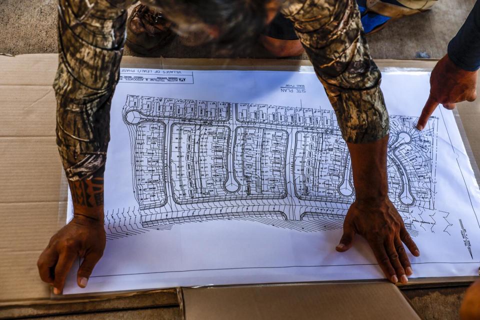 Volunteers prepare a map to document homes that need roof repair