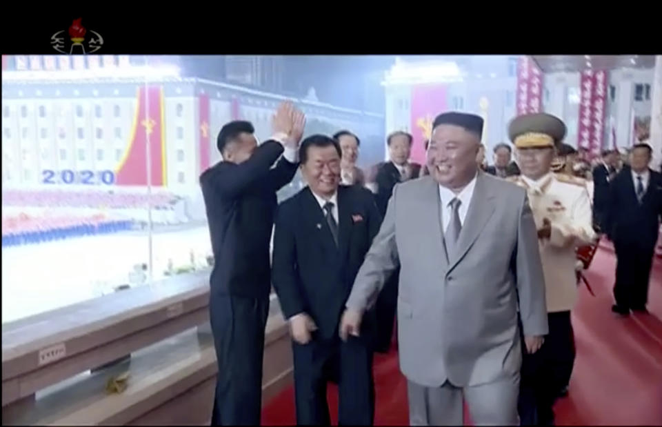 In this image made from video broadcasted by North Korea's KRT, North Korean leader Kim Jong Un, center, smiles as he leaves a ceremony to celebrate the 75th anniversary of the country’s ruling party in Pyongyang Saturday, Oct. 10, 2020.(KRT via AP)