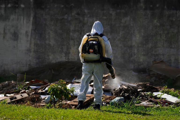 Un trabajador de salud pública fumiga el terreno de una escuela pública como parte de una campaña contra los mosquitos portadores del dengue en el vecindario de  Sao Sebastiao de Brasilia