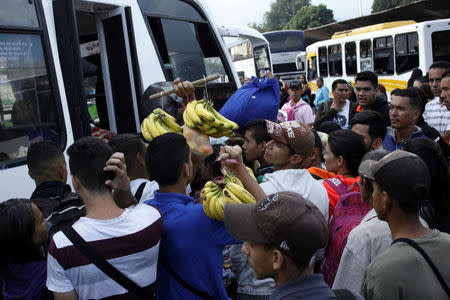 People carrying goods try to find a spot on a bus to travel to the city of San Antonio near the Colombian border at the bus station in San Cristobal, Venezuela December 14, 2017. REUTERS/Carlos Eduardo Ramirez
