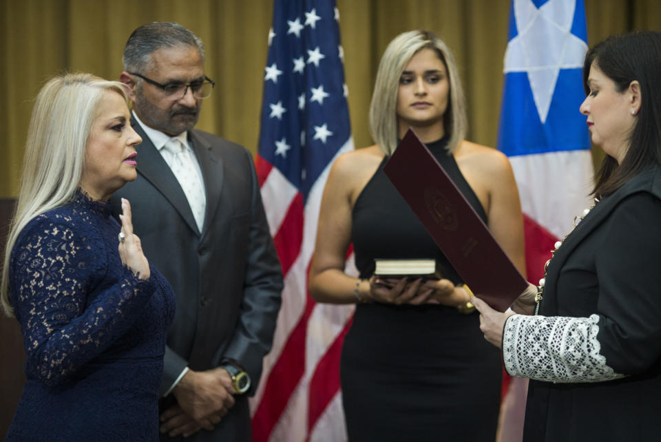 Justice Secretary Wanda Vazquez is sworn in as governor of Puerto Rico by Supreme Court Justice Maite Oronoz, in San Juan, Puerto Rico, Wednesday, Aug. 7, 2019. Vazquez took the oath of office early Wednesday evening at the Puerto Rican Supreme Court, which earlier in the day ruled that Pedro Pierluisi's swearing in last week was unconstitutional. Vazquez was joined by her daughter Beatriz Diaz Vazquez and her husband Judge Jorge Diaz. (AP Photo/Dennis M. Rivera Pichardo)