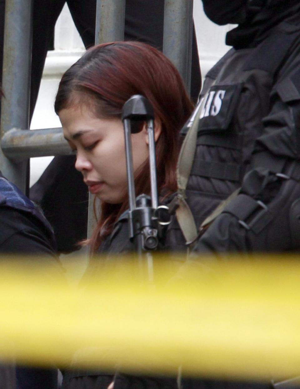 Indonesian suspect Siti Aisyah in the ongoing assassination investigation, is escorted by police officers out from Sepang court in Sepang, Malaysia on Wednesday, March 1, 2017. Two women accused of smearing VX nerve agent on Kim Jong Nam, the estranged half brother of North Korea's leader, were charged with murder Wednesday after arriving in court under heavy protection. (AP Photo/Daniel Chan)