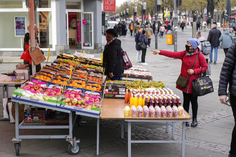 People choose fruits and vegetables to buy at a street market in Berlin, April 2022