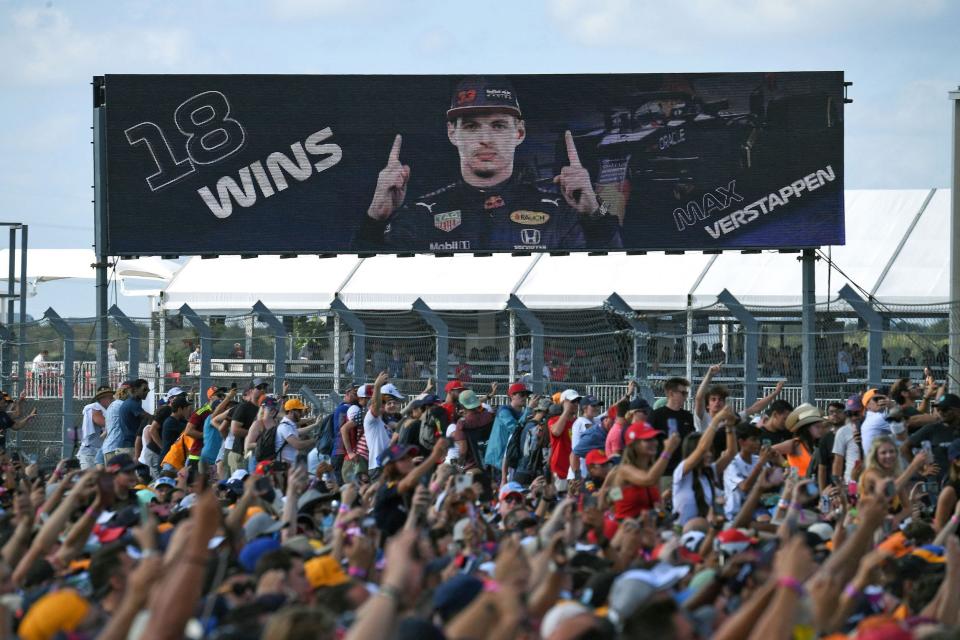 People gather under a screeen announcing Red Bull's Dutch driver Max Verstappen nexto the winner's podium at the Formula One United States Grand Prix at the Circuit of The Americas in Austin, Texas