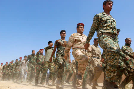 FILE PHOTO: Popular Mobilisation Forces (PMF) march during a military parade in Daquq, nearby Kirkuk, Iraq August 5, 2017. REUTERS/Ako Rasheed/File Photo