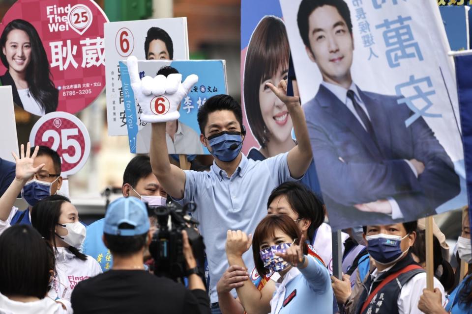 蔣萬安14日一早與市議員候選人站路​口拜票。林啟弘攝