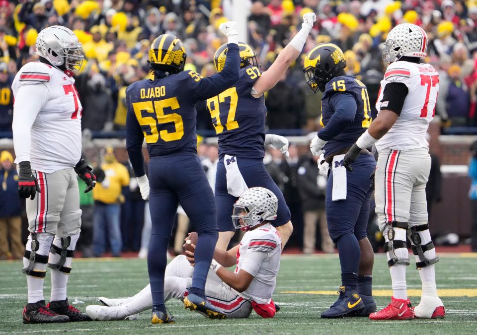 Michigan Wolverines linebacker David Ojabo and defensive end Aidan Hutchinson celebrate a sack of Ohio State Buckeyes quarterback C.J. Stroud during the 2021 rivalry game. All three are in the NFL now.