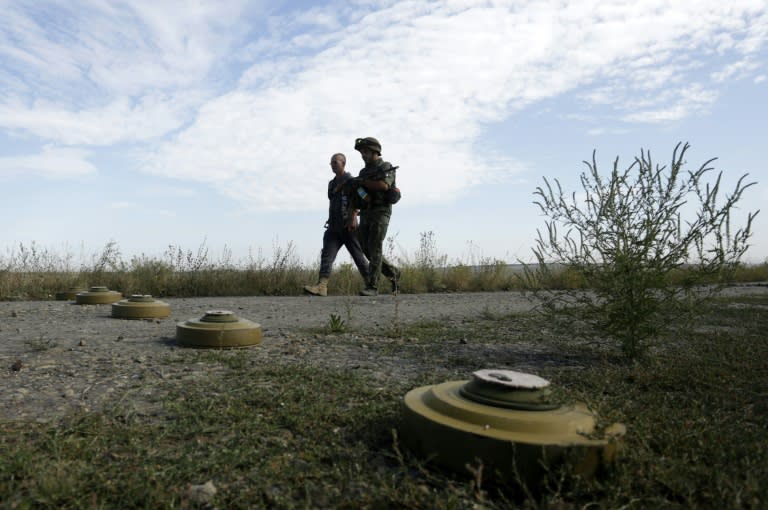 Servicemen walk past anti-tank mines set on the position of Ukrainian forces in the Lugansk region on August 27, 2015